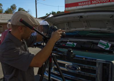 Man photographing the inside of a U-Haul truck engine.