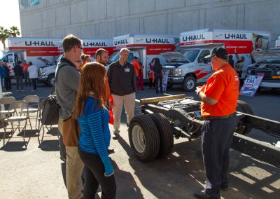 Several people viewing a U-Haul truck demonstration.