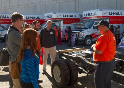 Several people viewing a U-Haul truck demonstration.