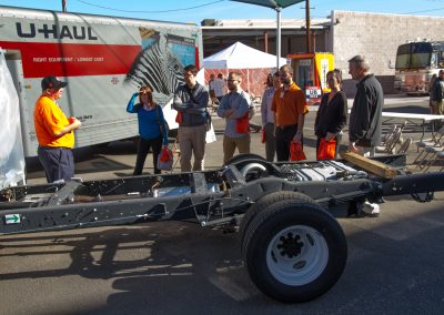 A small group of people viewing a U-Haul truck demonstration.