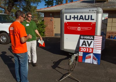 Two men looking at a U-Haul trailer.