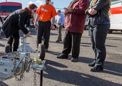 A woman giving a trailer demonstration to several onlookers.