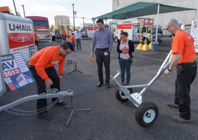 Two men showing how to use a trailer dolly.