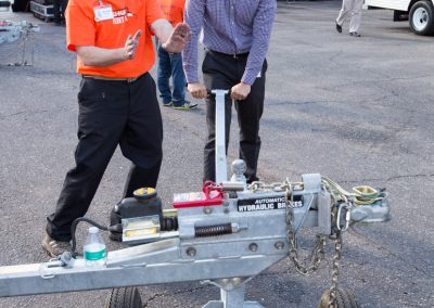 Two men showing how to use a trailer dolly.