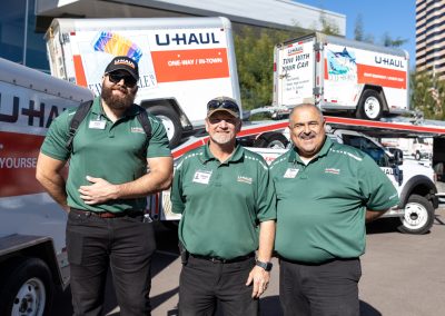 U-Haul employees posing in front of U-Haul equipment.