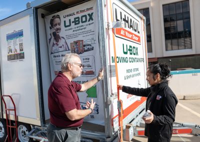 U-Haul employees having a conversation near a U-Box container.