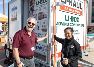 Two U-Haul employees posing in front of a U-Box container.