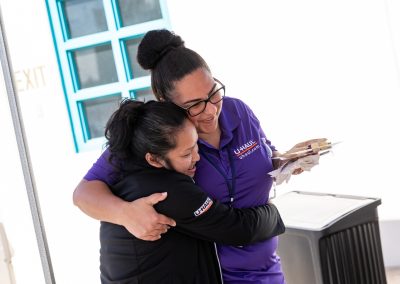 Two female U-Haul employees hugging each other.